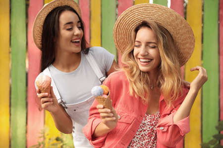 Young women with ice cream spending time together outdoors