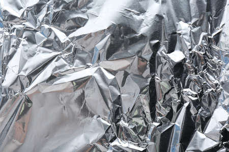 Crumpled silver foil as background, closeup view