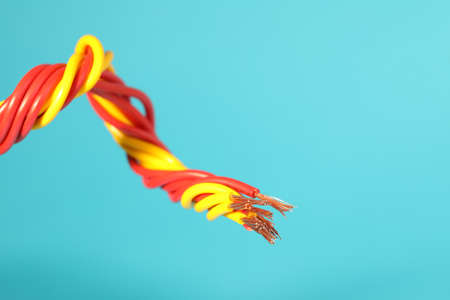 Electrical wires on light blue background, closeup. Space for textの写真素材