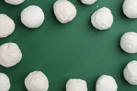 Frame of snowballs on green background, flat lay. Space for textの写真素材