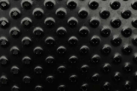 Modern black grater as background, top view