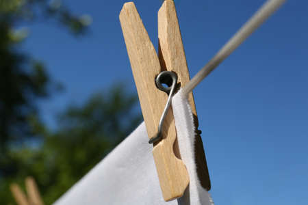 Washing line with clean laundry and clothespin outdoors, closeup