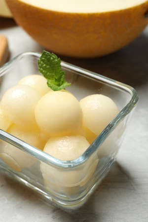 Melon balls with mint in glass bowl on table, closeupの写真素材