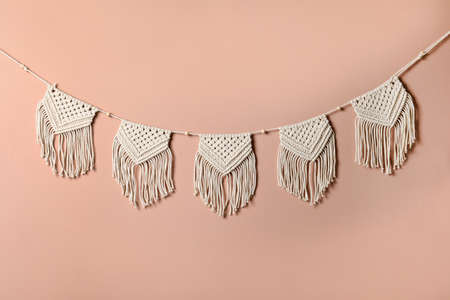 Stylish large macrame hanging on pink wall