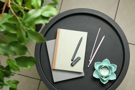 Notebooks, pen, pencils and decor on round table indoors, top viewの写真素材