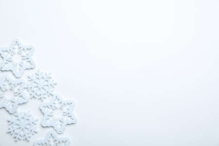 Beautiful decorative snowflakes on white background, flat lay. Space for text