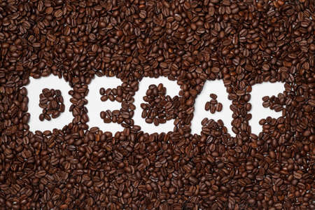 Word Decaf in coffee beans on white background, top viewの写真素材
