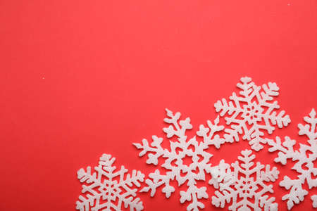 Beautiful decorative snowflakes on red background, flat lay. Space for textの写真素材