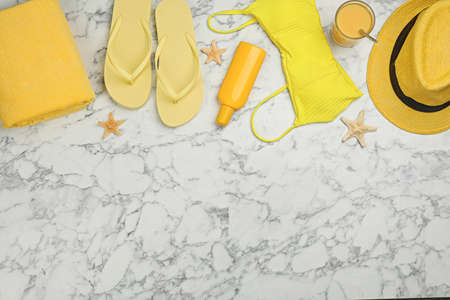 Flat lay composition with beach objects on white marble background, space for text