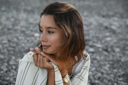 Portrait of beautiful young woman on pebble beachの写真素材