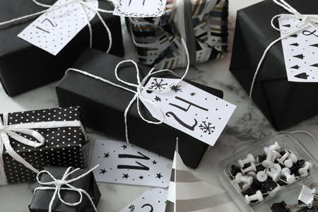 Set of gift boxes and pins on white marble table. Creating an advent calendar