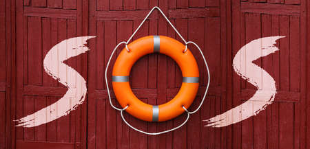 SOS message made from lifebuoy and letters on red wooden wall. banner design