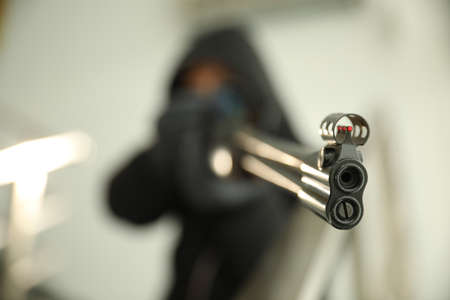 Hired professional killer indoors, focus on sniper rifleの写真素材