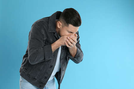 Man suffering from nausea on light blue background, space for text. food poisoning