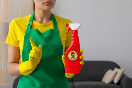 Woman showing bottle of toxic household chemical with warning sign, closeupの写真素材