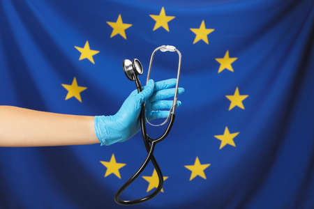 Woman holding stethoscope against flag of European Union, closeupの写真素材