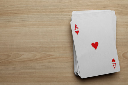 Deck of playing cards on wooden table, flat lay. Space for textの写真素材