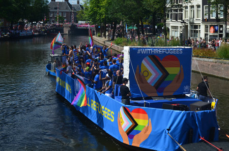 AMSTERDAM, NETHERLANDS - AUGUST 06, 2022: Many people in boat at LGBT pride parade on river