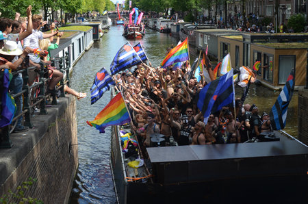 AMSTERDAM, NETHERLANDS - AUGUST 06, 2022: Many people in boats at LGBT pride parade on riverのeditorial素材