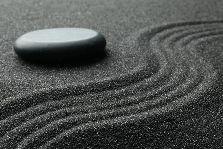 Zen garden stone on black sand with pattern, closeupの写真素材
