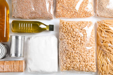Different products on white wooden table, flat lay. food donation