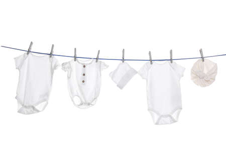 Different baby clothes drying on laundry line against white backgroundの写真素材