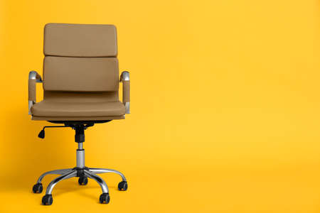 Modern office chair on yellow background. Space for textの写真素材