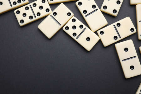 Classic domino tiles on black background, flat lay. Space for textの写真素材