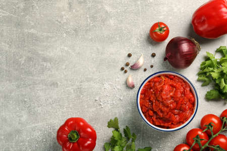 Delicious lecho in bowl and fresh ingredients on light gray table, flat lay. Space for textの写真素材