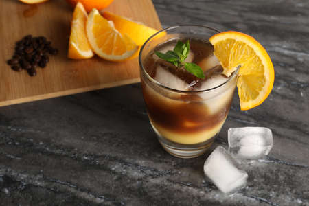 Tasty refreshing drink with coffee and orange juice on gray marble table, space for textの写真素材
