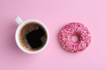 Tasty donut and cup of coffee on pink background, flat layの写真素材