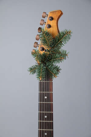 Guitar with fir tree branch on gray background. christmas musicの写真素材