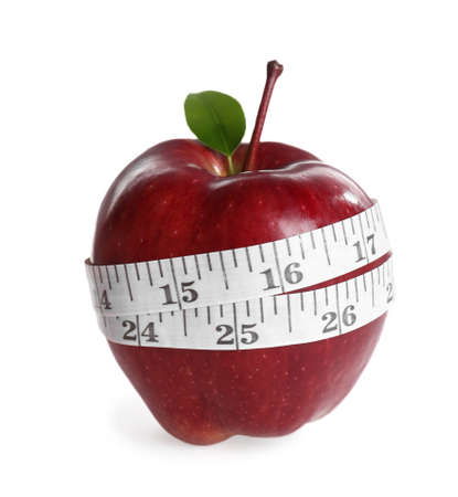 Fresh ripe red apple with measuring tape on white backgroundの写真素材