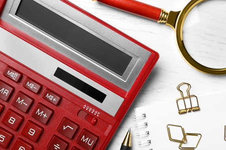 Calculator and stationery on white wooden table, flat lay. tax accountingの写真素材