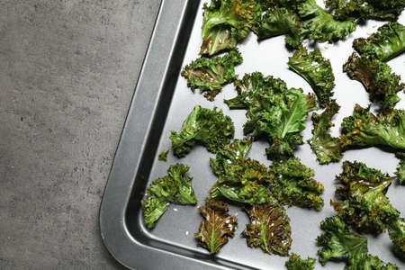 Tasty baked kale chips on gray table, top viewの写真素材