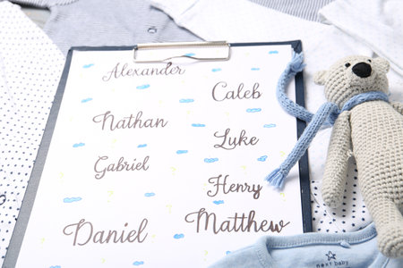 Clipboard with different baby names and toy on child's clothes, closeupの写真素材