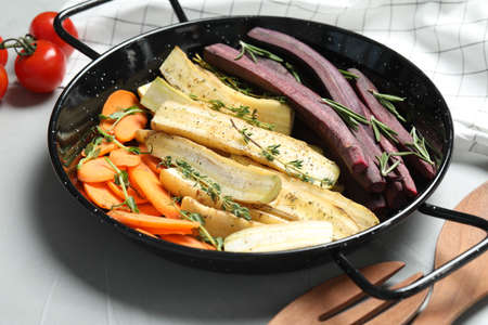 Raw cut carrots in frying pan on light gray table, closeupの写真素材