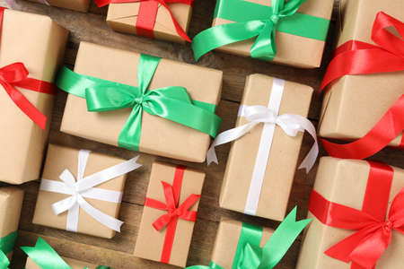 Christmas gift boxes with bows on wooden background, flat layの写真素材