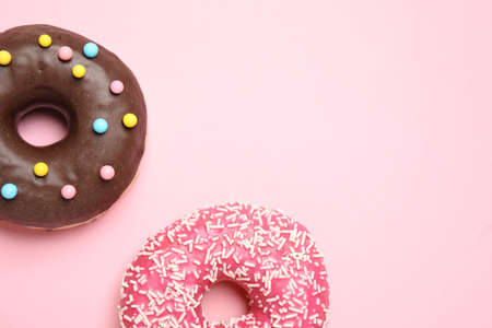 Delicious glazed donuts on pink background, flat lay. Space for textの写真素材
