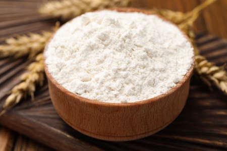 Bowl of organic wheat flour on wooden table, closeupの写真素材