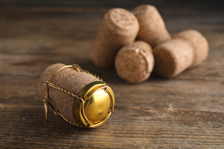 Cork of sparkling wine and muselet cap on wooden table, closeup. Space for textの写真素材