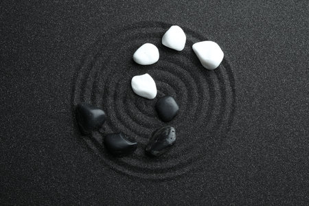 Stones on black sand with beautiful pattern, flat lay. Zen and harmonyの写真素材