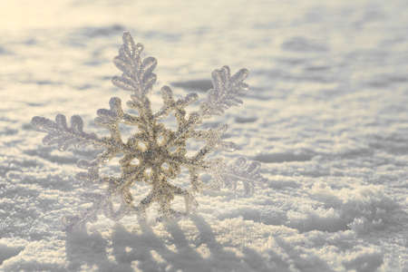 Beautiful decorative snowflake in white snow, outdoors. Space for text