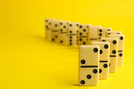 Row of white domino tiles on yellow background. Space for textの写真素材