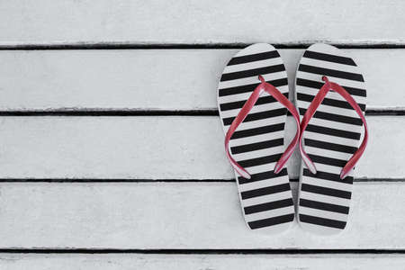 Stylish flip flops on white wooden table, flat lay. Space for textの写真素材