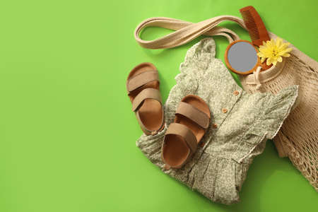 Stylish child clothes, shoes and accessories on green background, flat lay. Space for textの写真素材