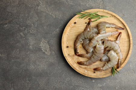 Fresh raw shrimps with rosemary on gray table, top view. Space for textの写真素材