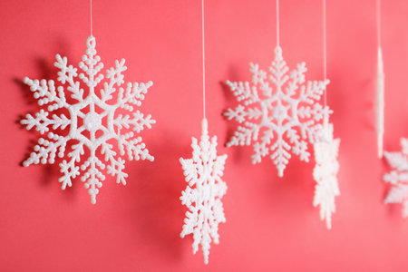 Beautiful decorative snowflake hanging on red background, closeupの写真素材