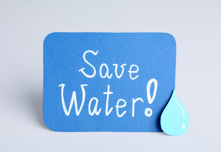 Card with words Save Water and paper drop on light gray backgroundの写真素材