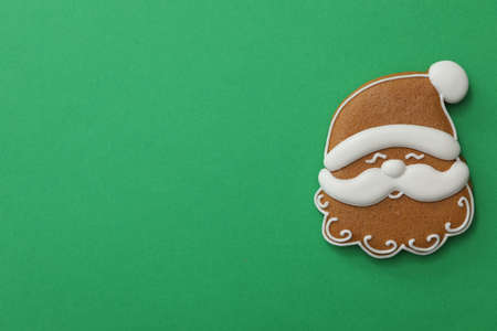 Christmas Santa Claus face shaped gingerbread cookie on green background, top view. Space for textの写真素材